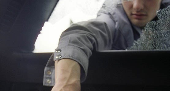 Tjuv krossar bilruta.