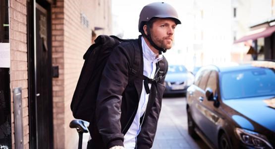 Man leder cykel på trottoar.