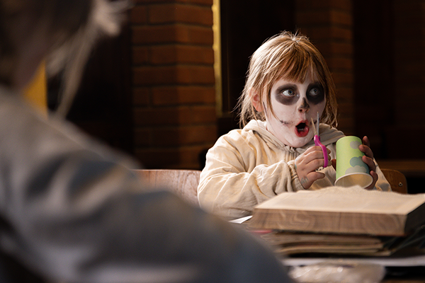 Barn med spöksminkning som pysslar