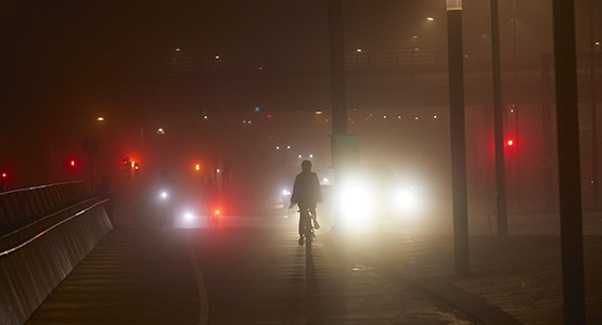 Cyklist på bilväg i mörker.