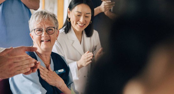 Kvinna i vårdkläder blir avtackad inför sin pension.ad