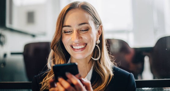 Kvinna i kostym läser om sin pension i sin mobil.