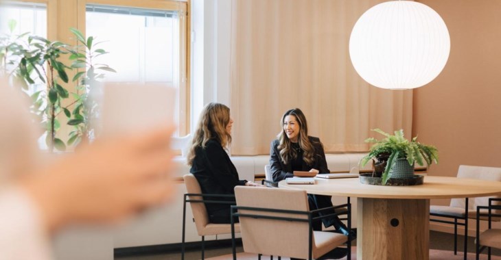 Foto av två kvinnor i kontorsmiljö.