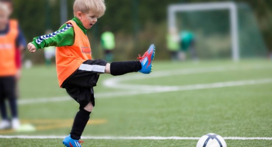 Liten pojke spelar fotboll