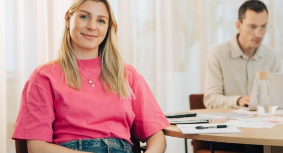 Glad ung kvinna tittar in i kameran