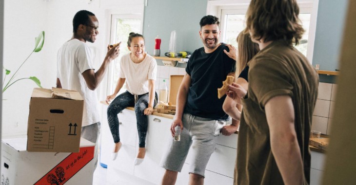 Personer äter flyttpizza tillsammans under flytt.