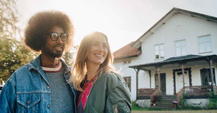 Bild på ett par som står framför sin nyköpta villa.