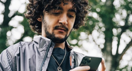 Ung man tittar bekymrat på mobiltelefon.