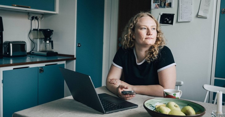 Kvinna kollar sitt sparkonto  och drömmer sig bort.