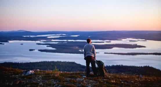 person som blickar ut över fjälltoppar.