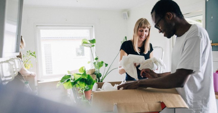 Bild på två ungdomar som packar upp ur en flyttkartong.