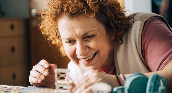 Kvinna målar och är nöjd med sitt månadssparande.