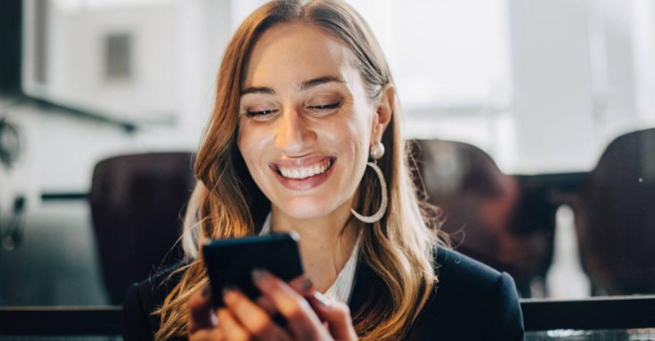 Tjej kollar utvecklingen av sin indexfond i sin mobil.