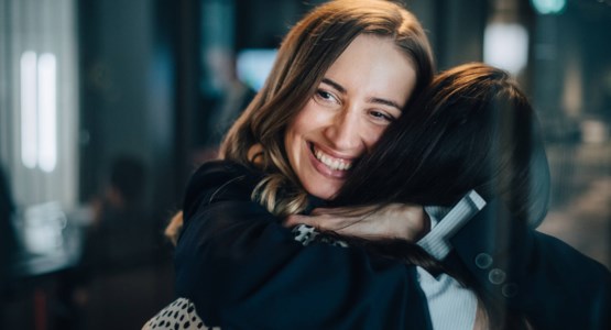 kvinnor kramas på kontor