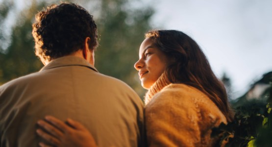 En grupp nedstämda människor på en begravning utomhus.