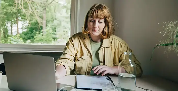 Kvinna i 40-årsåldern ser över sitt privata pensionssparande.