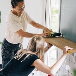 Tjejer sätter upp en hylla.