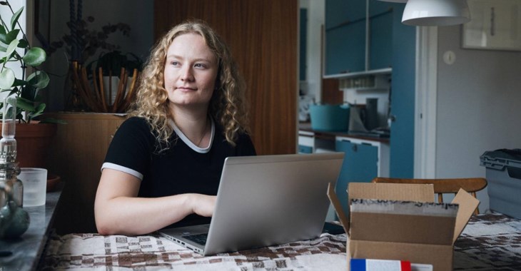 Foto på en ung kvinna vid laptop som läser om skillnaden mellan ISK och kapitalförsäkring.