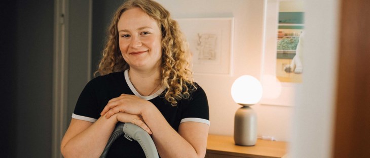 Ung kvinna med dammsugare.