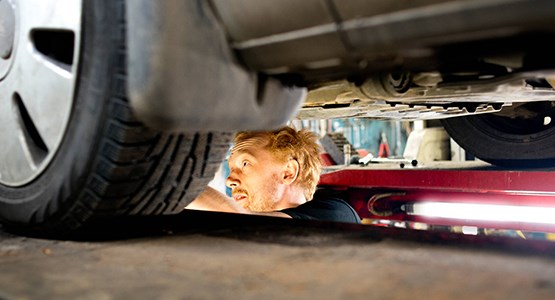 Man som reparerar en bil