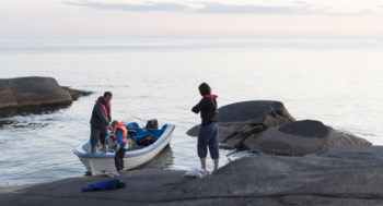 Familj på liten båt i skärgården.
