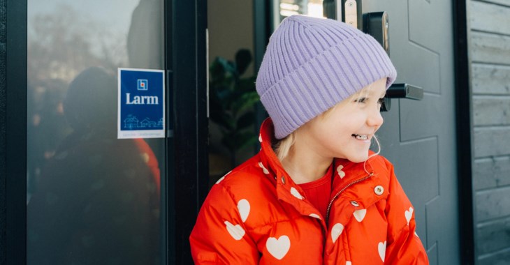 Barn står vid dörr där det står "larm" på.