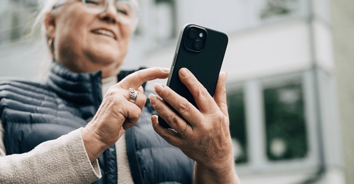 Kvinna scrollar i mobiltelefon.