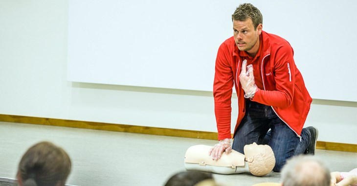 Kursledaren Mathias visar HLR på en docka.