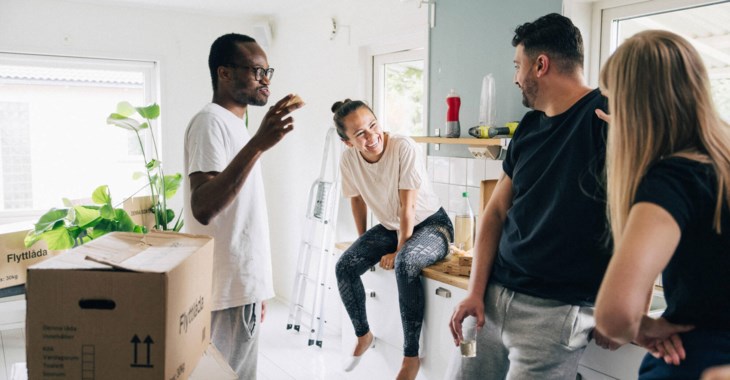 Fyra glada personer i ett nyinflyttat kök.