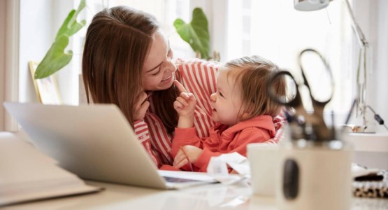 Mamma och litet barn tittar på varandra och skrattar.