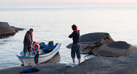 Familj vid båt.