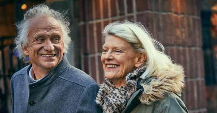 Ett äldre leende par är ute och promenerar.
