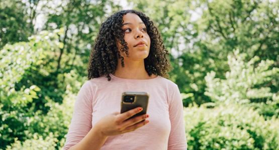 Kvinna med mobil i handen.