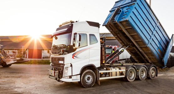 Lastbil och hjullastare arbetar på gårdsplan.