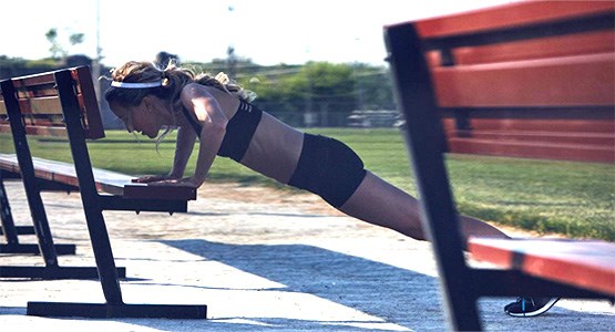 Kvinna tränar Hyrox utomhus.