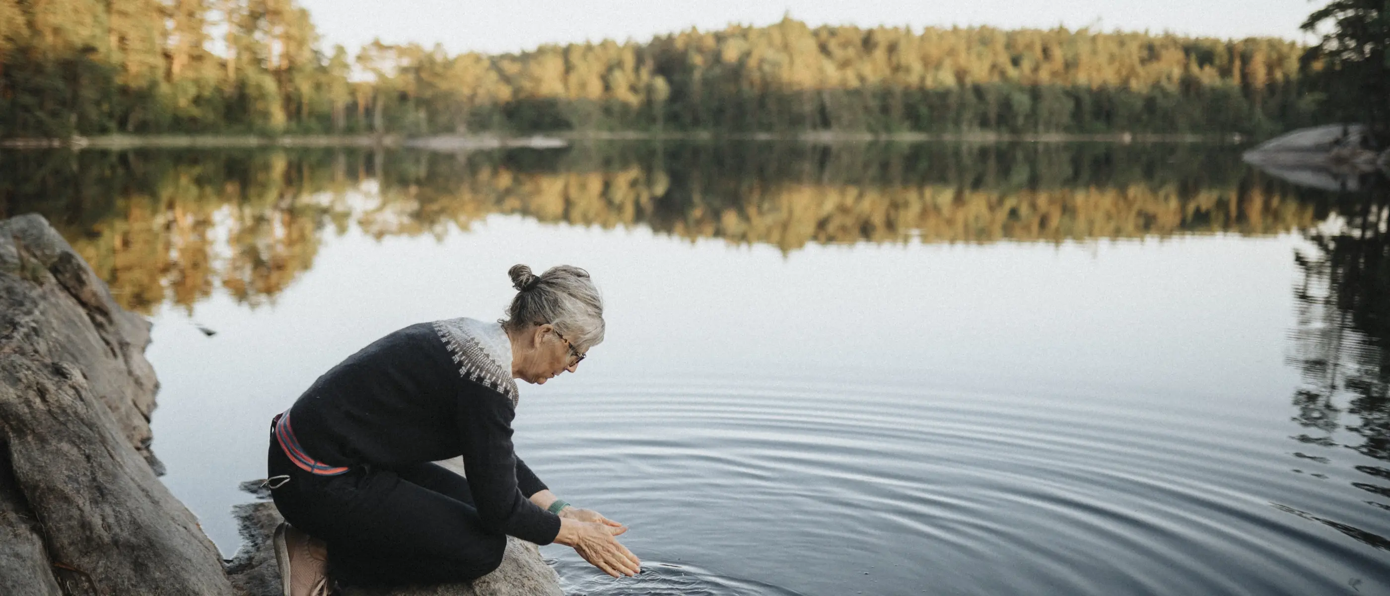 Kvinna tvättar händerna i sjö.