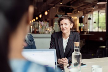 Kvinna på lunchmöte med kollegor.