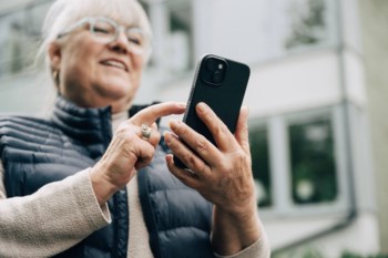 Kvinna tittar på sin mobiltelefon.