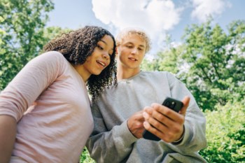 Ungdomar tittar i sin mobil.