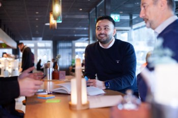 Tjej pratar med en kollega över lunchen.