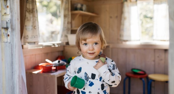 Litet barn som leker i lekstuga