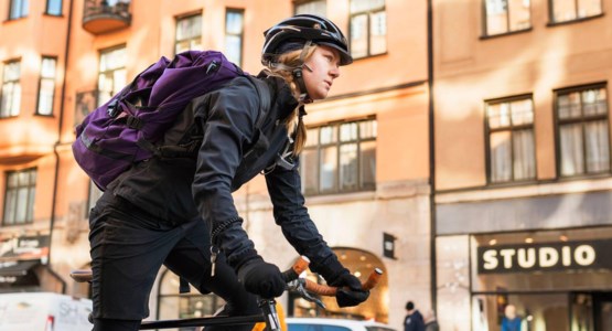 Kvinna på cykel i stadsmiljö.
