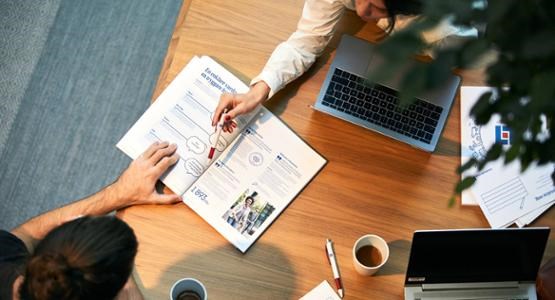 Möte mellan två personer som sitter vid ett bord och tittar i ett dokument.