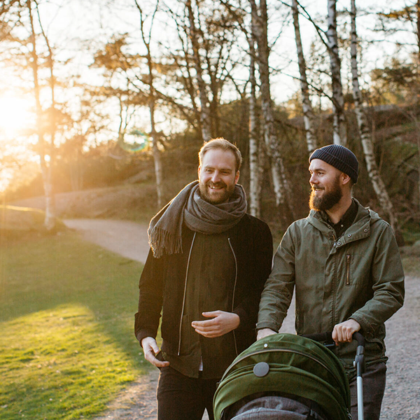 Två män på barnvagnspromenad i solen.