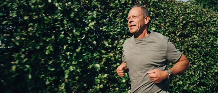 Man springer längs häck.