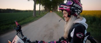 Tjej sitter på moped.