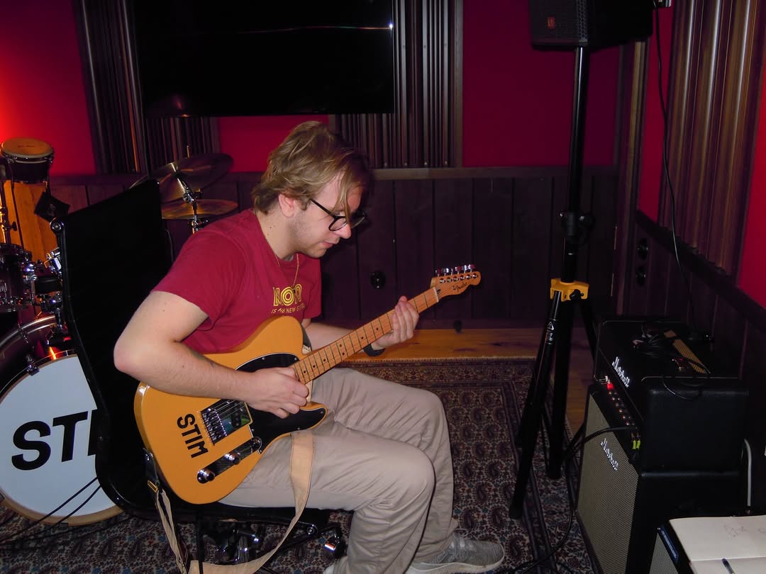 En ung kille spelar gitarr.