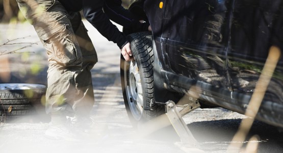 Person som byter däck på bil