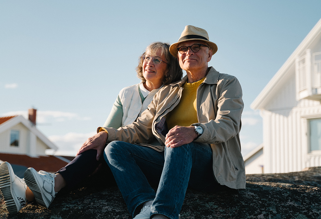 Äldre par utanför hus - foto