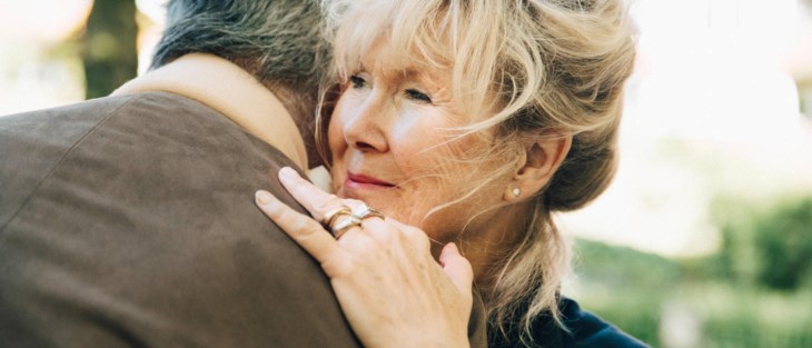 Äldre par kramas.